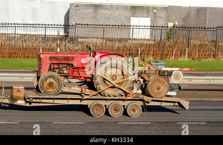 An International Harvester B-275 Utility tractor being towed along the Kingsway West dual Carriageway in Dundee, UK Stock Photo