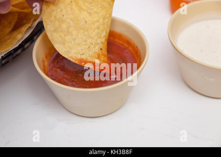 Dipping a tostada chip in salsa Stock Photo