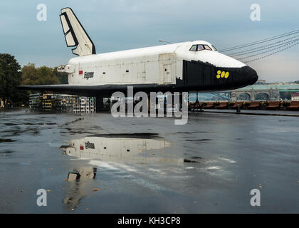 Buran - Orbital Soviet reusable space ship in Gorky Park, Moscow. Reflection of the space ship in a puddle on the asphalt. Stock Photo