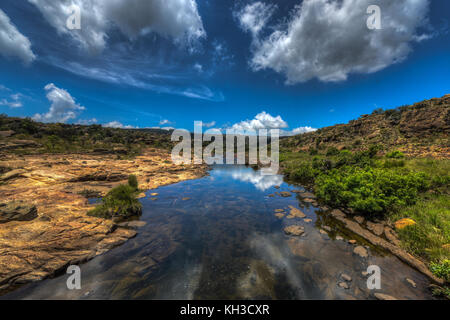 Treur River Crossing reflecting the sky. The Treur River (from Afrikaans: mourning river) is a small river in the Drakensberg escarpment region of eas Stock Photo