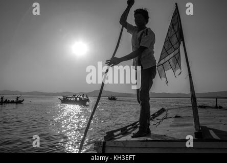 Boatman on an old riverboat at sunrise on the Irrawaddy River (Ayeyarwaddy River) in Myanmar (Burma).  It is the country's largest river and most impo Stock Photo