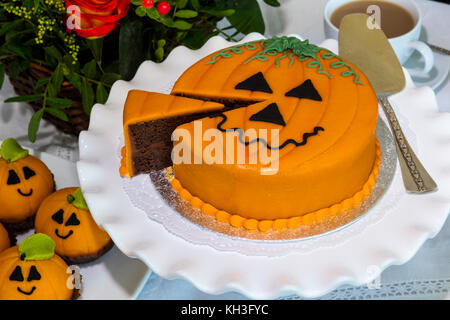 Novelty chocolate cake cut and decorated with marzipan and icing in Halloween theme. Stock Photo