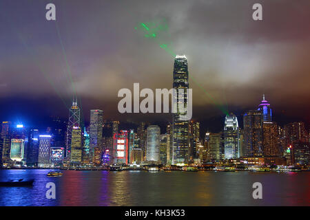 Lights of the city skyline of Central across Victoria Harbour and Symphony of Lights light show at night in Hong Kong, China Stock Photo