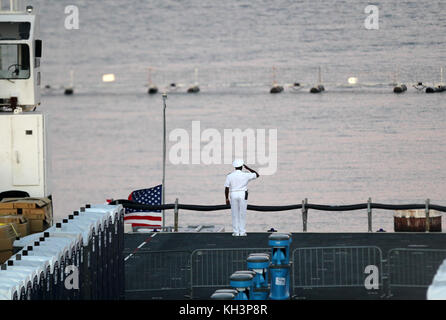 November 10, 2012--  A Naval Officer salutes the american flag as it is lowered off thedeck of USS Battan prior to sunset of Navy Marine Corps Classic at Mayport Naval Station in Jacksonville, FL Credit: mpi34/MediaPunch Inc Stock Photo