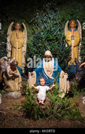 Christmas nativity scene with Mary, Joseph and angels looking down on baby Jesus in his manger Stock Photo