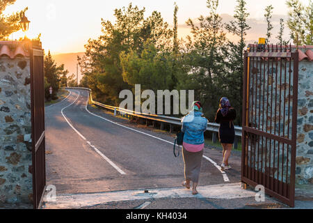 Tourists at Stavrovouni monastery - entrance and road at sunset Stock Photo