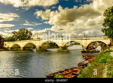 Richmond Bridge spanning over the river Thames and rowing boats in summer on a overcast day, London England U.K Stock Photo