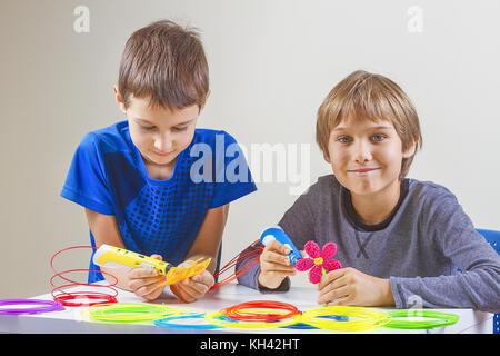 Two boys creating with 3d printing pens Stock Photo - Alamy