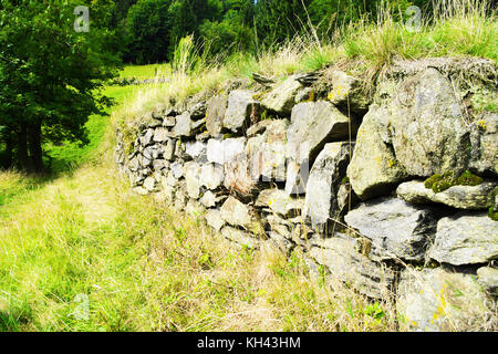 Stone retaining wall. Old rough retaining wall alongside the hiking trail in the Owl Mountains Landscape Park, Sudetes, south-west Poland. Stock Photo