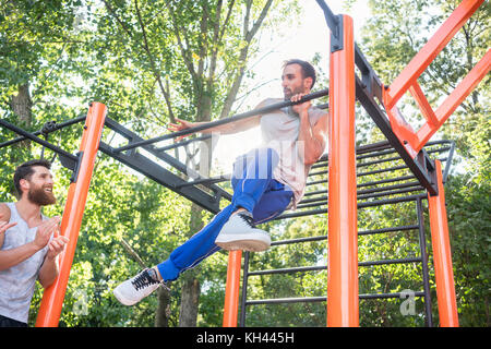 Strong young man doing amazing pull-up variation during extreme  Stock Photo