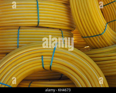Cable bright yellow, folded into huge coils, bundles that lie together in a heap. Stock Photo