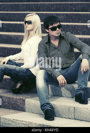Young fashion man and woman in conflict sitting on the steps Stock Photo