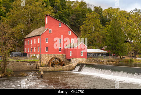 The historic Red Mill in Clinton NJ with people fishing in the river. The village also decorated for halloween as  photo taken in Mid October Stock Photo