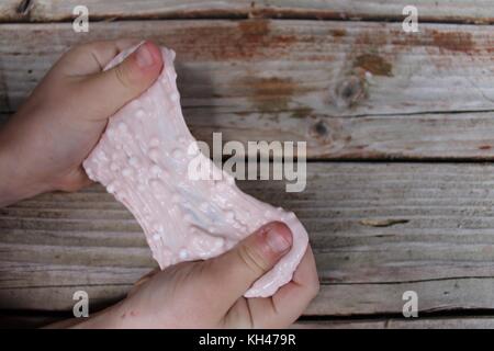 slime with foam beads in child's hands Stock Photo