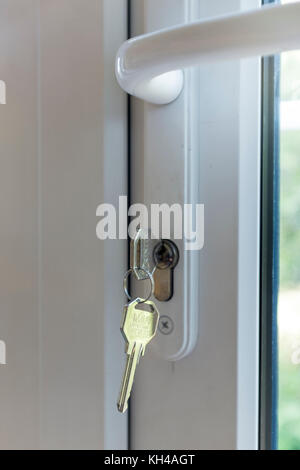 Close up of key in white UPVC patio door of house Stock Photo