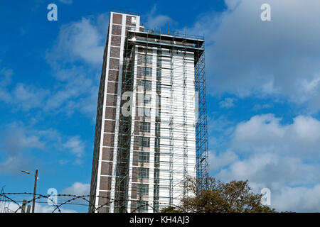 Underview of high skyscraper building with scaffolding undergoing renovations against blue cloudy sky in South Africa Stock Photo