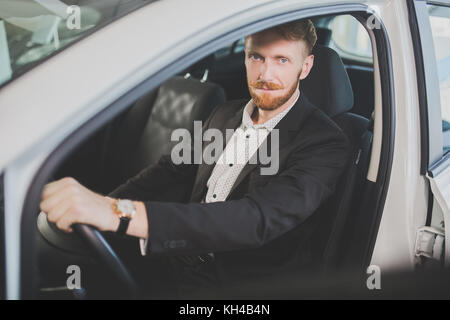 Young handsome man bying car, inspecting interior of the vehicle. Stock Photo