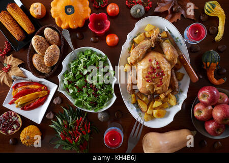 Thanksciving table full with traditional food and decorated with gourds, berries, leaves and candles, flat lay, top view. Stock Photo