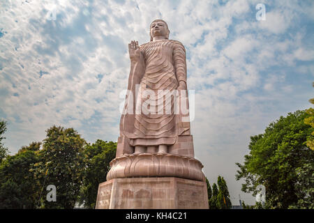 Gigantic sculpture of standing Buddha 80 feet tall at Wat Thai monastery Sarnath, Varanasi, India. Stock Photo