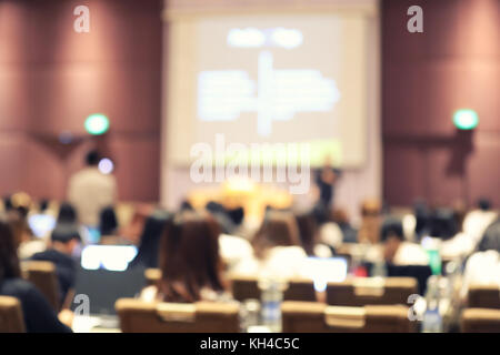 Abstract blurry background of employees seminar and De-focus teamwork staffs working meeting in conference room with projector screen. Stock Photo