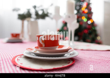 Interior light grey kitchen and red christmas decor. Preparing lunch at home on the kitchen concept. Stock Photo