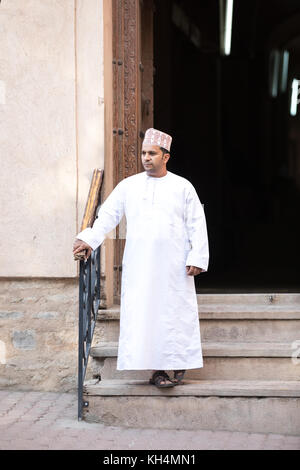 Omani man in a traditional outfit standing on the edge of a staircase. Nizwa, Oman. Stock Photo