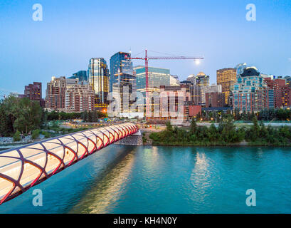 Calgary downtown with iluminated Peace Bridge and full moon, Alberta, Canada Stock Photo