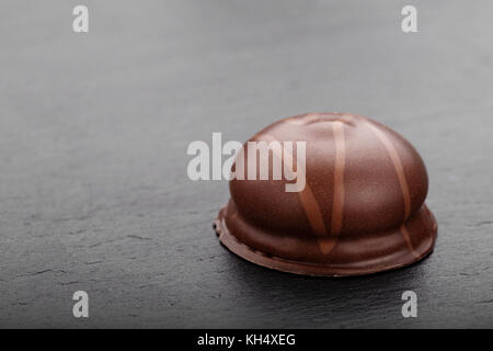 chocolate candy, on a slate board, on a black background minimalism, space for text Stock Photo