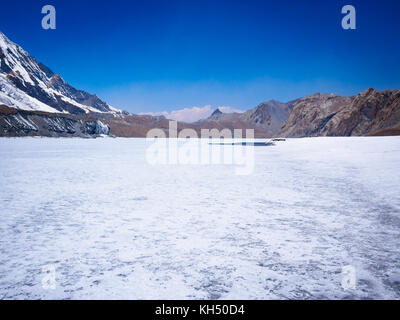 White frozen expanse of Tilicho Lake in the Annapurna Himalayas, Nepal Stock Photo