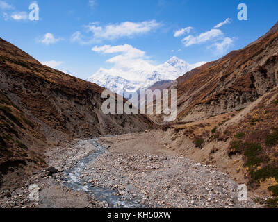 High altitude river valley between Ledar and Thorung Phedi, with Gangapurna and Annapurna III peaks in the background. Annapurna Circuit Trek, Nepal Stock Photo