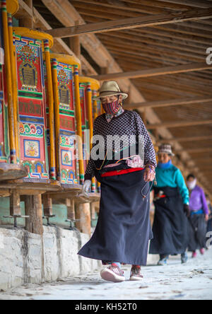 Tibetan pilgrims turning huge prayer wheels in Labrang monastery, Gansu province, Labrang, China Stock Photo