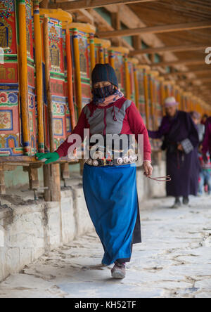 Tibetan pilgrims turning huge prayer wheels in Labrang monastery, Gansu province, Labrang, China Stock Photo