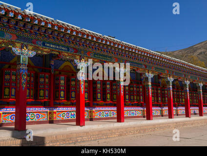 Beautifully painted and adorned prayer wheels in Wutun si monastery, Qinghai province, Wutun, China Stock Photo