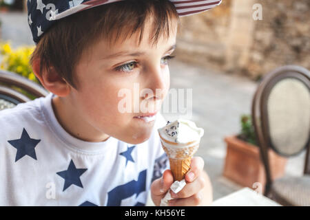 Young boy eating an ice cream on a terrace in Italy Stock Photo