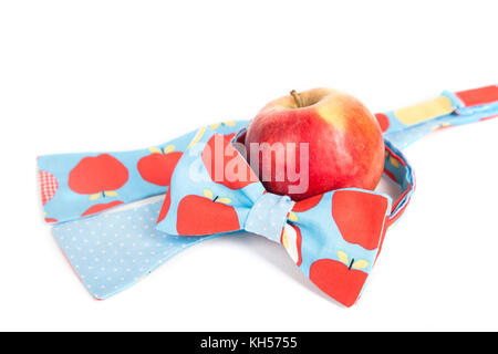 funny tie bow with big red polka dots in front of red apple, close up, fruit, fresh Stock Photo