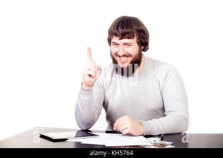 Young hipster man with thumb up, sitting at the table, in front of white background Stock Photo