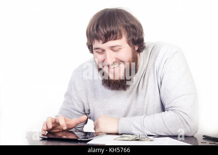 Accountant using a tablet computer, man smiling sitting at a desk, Internet surfing Stock Photo