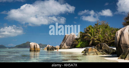 The Seychelles, La Digue, L’Union Estate, tourists in sea at Anse Source d’Argent beach, panoramic Stock Photo