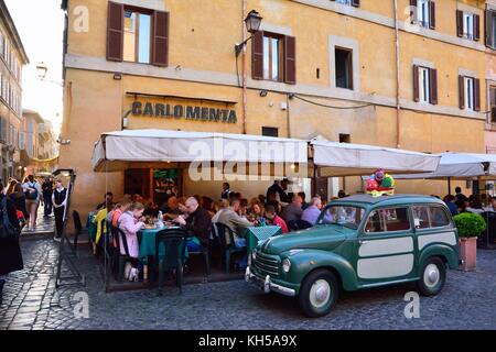 ROME, ITALY - APRIL 10, 2017: People eating traditional italian food in outdoor restaurant Carlo Menta in Trastevere district in Rome, Italy Stock Photo