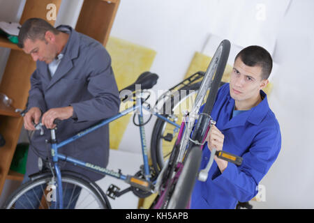 2 men repairing bicycles in the workshop Stock Photo