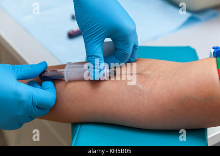 the doctor takes blood from the vein on the arm Stock Photo