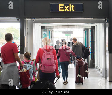 People leaving Stansted Airport via EXIT sign from International Arrivals Stock Photo