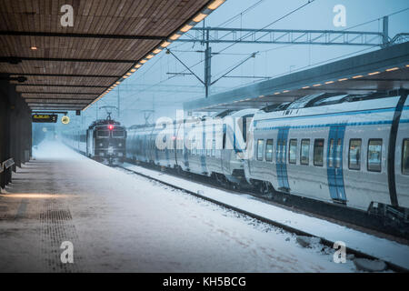 Winter blizzard, train arriving at railway station. Uppsala, Sweden. Scandinavia. Stock Photo