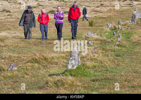 Visitors at Merrivale Prehistoric Settlement, walking by the Merrivale stone row at Dartmoor National Park, Devon, UK in September Stock Photo