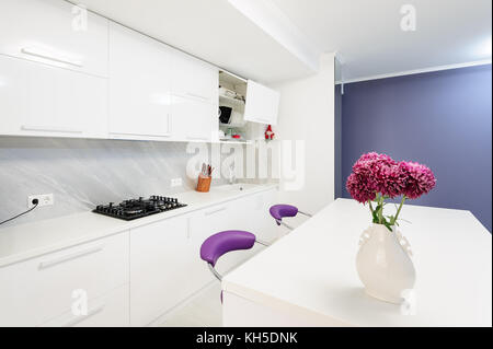 modern kitchen with dining table and purple chairs Stock Photo