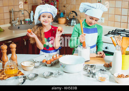 happy family funny kids are preparing the dough, bake cookies in the kitchen Stock Photo