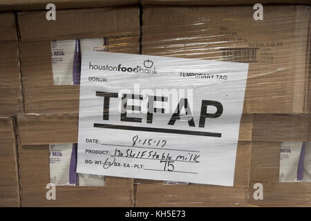 Pallets of USDA Emergency Food Assistance Program (TEFAP) commodities wait on the Houston Food Bank commodity warehouse shelves for movement to packing lines or delivery to food pantries; pallets in the aisles are loaded with disaster assistance packages (those with orange wrapping have USDA Foods in them), and are ready for delivery or distribution to those in need, in Houston, TX, on September 22, 2017. Houston Food Bank Operations Associate Director Marly Maskill provided the following information; in general, the food bank usually receives approximately 10 trucks per day and distributes ap Stock Photo