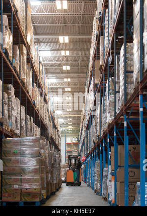 Pallets of USDA Emergency Food Assistance Program (TEFAP) commodities wait on the Houston Food Bank commodity warehouse shelves for movement to packing lines or delivery to food pantries; pallets in the aisles are loaded with disaster assistance packages (those with orange wrapping have USDA Foods in them), and are ready for delivery or distribution to those in need, in Houston, TX, on September 22, 2017. Houston Food Bank Operations Associate Director Marly Maskill provided the following information; in general, the food bank usually receives approximately 10 trucks per day and distributes ap Stock Photo