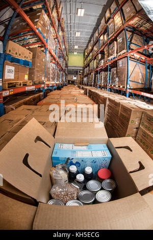 Pallets of USDA Emergency Food Assistance Program (TEFAP) commodities wait on the Houston Food Bank commodity warehouse shelves for movement to packing lines or delivery to food pantries; pallets in the aisles are loaded with disaster assistance packages (those with orange wrapping have USDA Foods in them), and are ready for delivery or distribution to those in need, in Houston, TX, on September 22, 2017. Houston Food Bank Operations Associate Director Marly Maskill provided the following information; in general, the food bank usually receives approximately 10 trucks per day and distributes ap Stock Photo