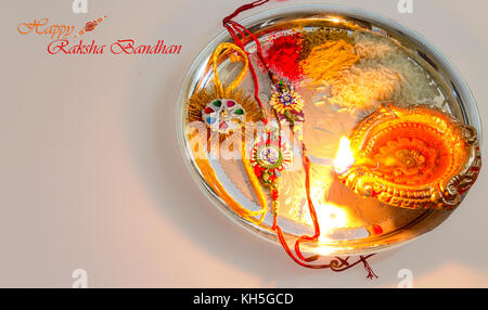 Raksha Bandhan Indian Hindu festival background content with rakhi, clay oil lamp, rice sweets and kumkum powder. Stock Photo